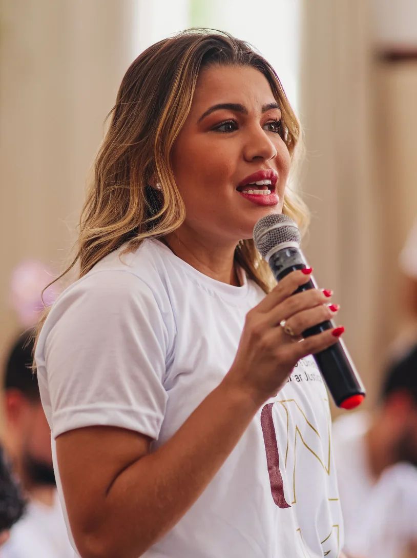 Laura falando ao microfone durante um evento