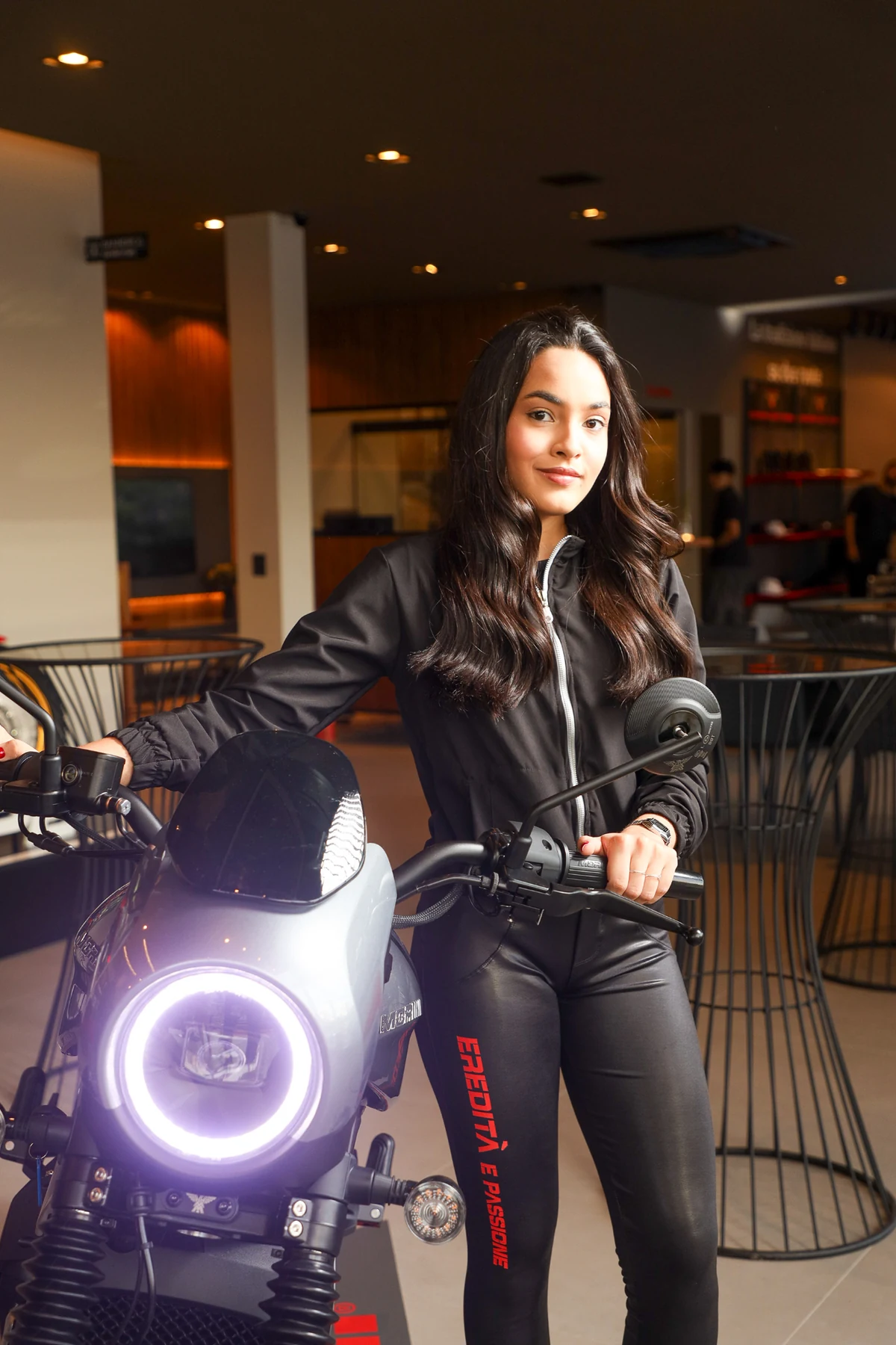 Participante ao lado de uma motocicleta em exposição durante uma ativação